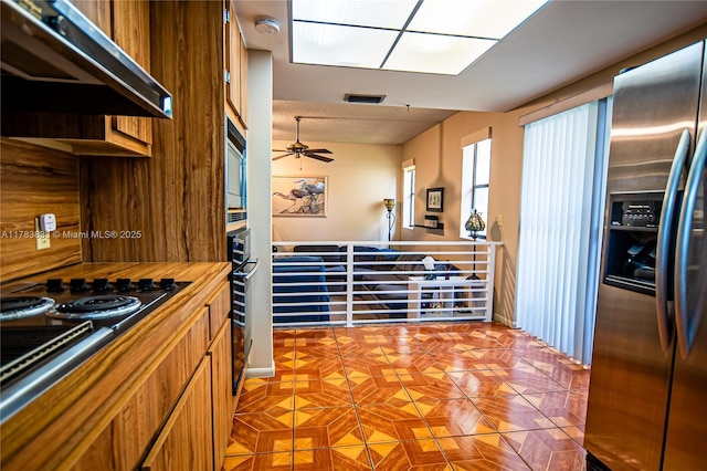17411 NW 62nd Ct, Hialeah, FL 33015 - kitchen featuring range hood, stainless steel fridge, a ceiling fan, black electric stovetop, and built in microwave