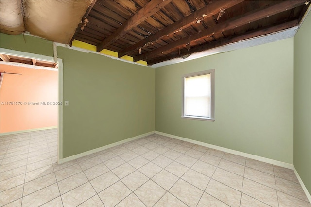 tiled empty room featuring wood ceiling, baseboards, and beam ceiling