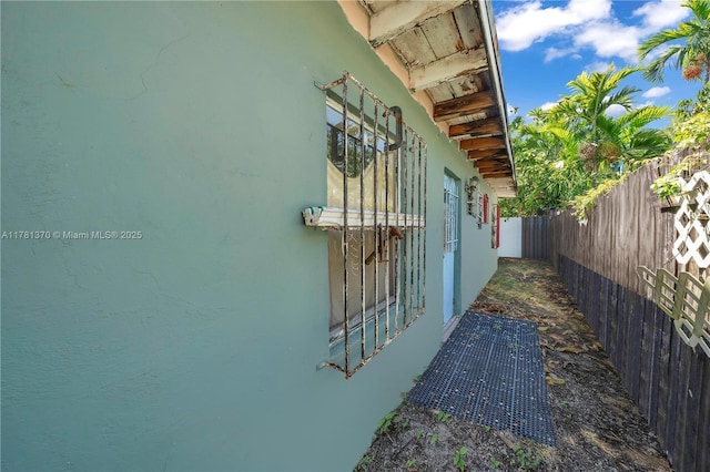view of home's exterior with fence and stucco siding