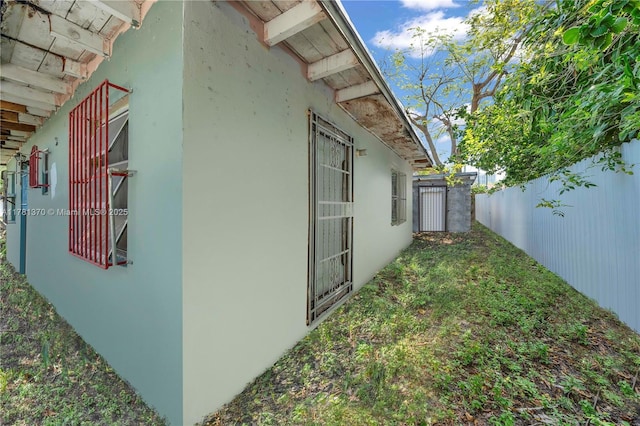 view of home's exterior featuring stucco siding and fence