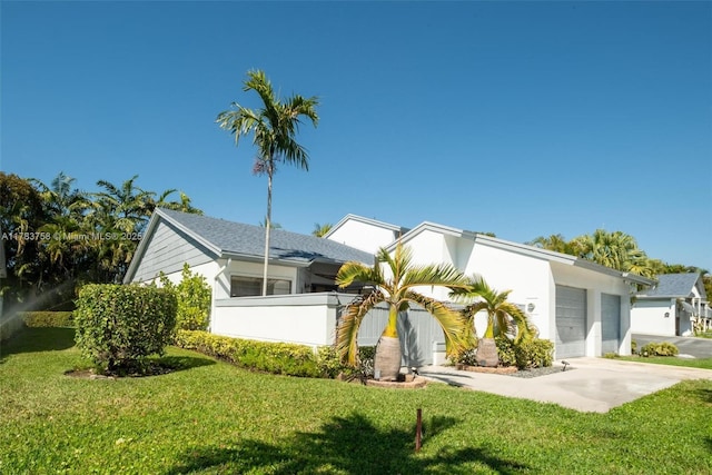 9909 NW 52nd Ln, Doral, FL 33178 - view of front of house featuring an attached garage, driveway, a front lawn, and stucco siding