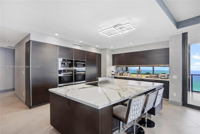 18555 Collins Ave Unit 5505, Sunny Isles Beach, FL 33160 - kitchen with oven, stainless steel oven, modern cabinets, a kitchen breakfast bar, and a large island