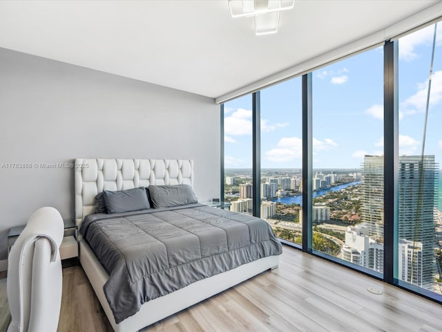 18555 Collins Ave Unit 5505, Sunny Isles Beach, FL 33160 - bedroom featuring a wall of windows, a view of city, multiple windows, a water view, and wood finished floors