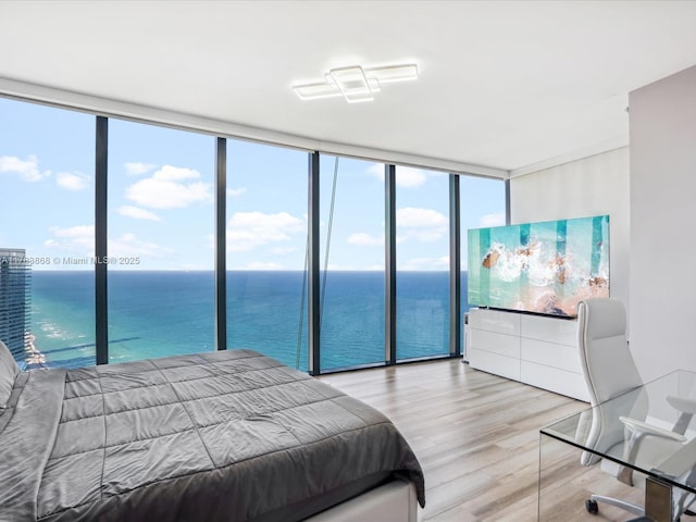 18555 Collins Ave Unit 5505, Sunny Isles Beach, FL 33160 - bedroom with light wood-style floors, a wall of windows, a water view, and multiple windows