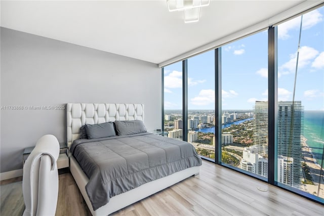 18555 Collins Ave Unit 5505, Sunny Isles Beach, FL 33160 - bedroom featuring a wall of windows, a water view, a view of city, and wood finished floors
