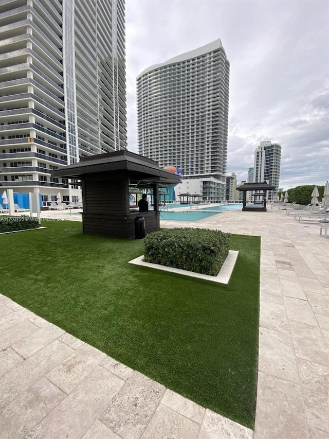 view of home's community featuring a swimming pool, a patio, and a yard