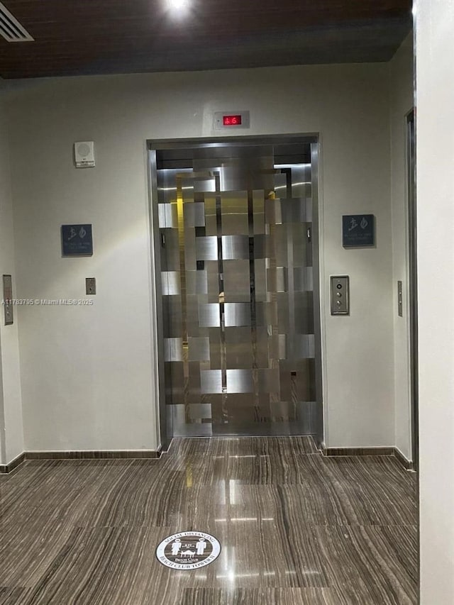 hallway with carpet flooring, baseboards, and visible vents