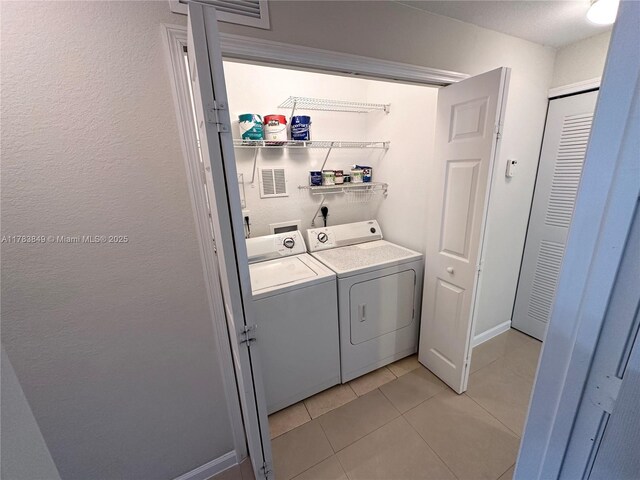 11202 NW 83rd St Unit 104, Doral, FL 33178 - laundry area with independent washer and dryer, light tile patterned flooring, laundry area, and baseboards