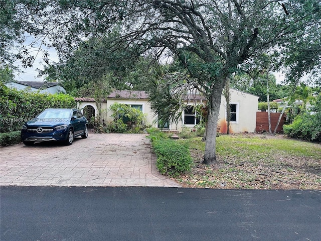 4371 SW 14th St, Miami, FL 33134 - view of property hidden behind natural elements featuring driveway, stucco siding, and fence