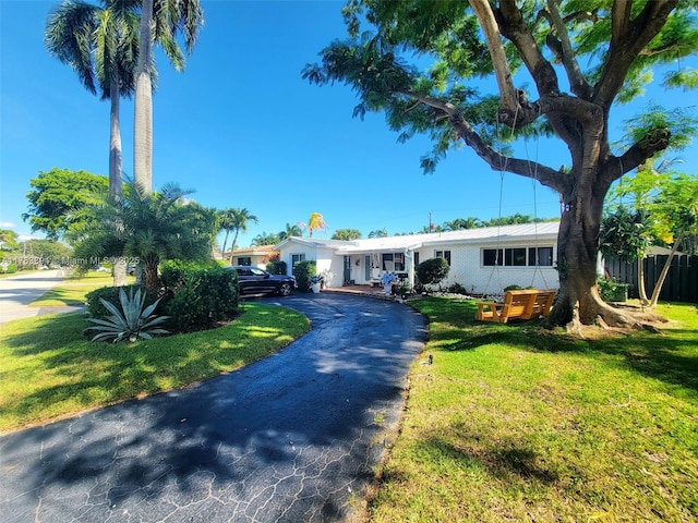 3602 NE 18th Ave, Oakland Park, FL 33334 - ranch-style house featuring a front yard, fence, and driveway