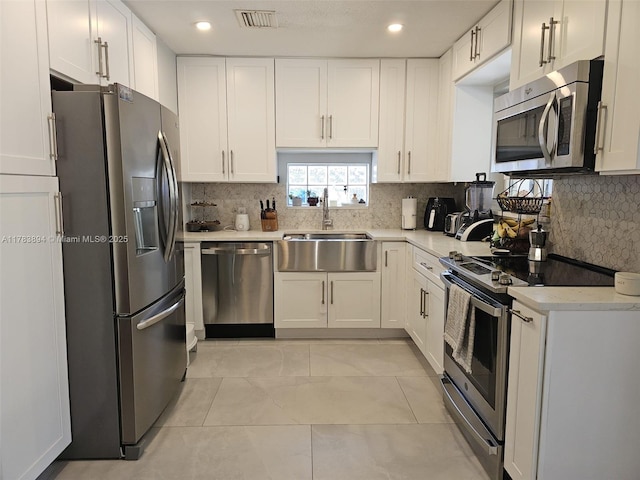 3602 NE 18th Ave, Oakland Park, FL 33334 - kitchen featuring visible vents, white cabinets, a sink, stainless steel appliances, and backsplash