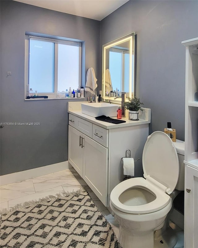 3602 NE 18th Ave, Oakland Park, FL 33334 - bathroom featuring vanity, marble finish floor, baseboards, and toilet