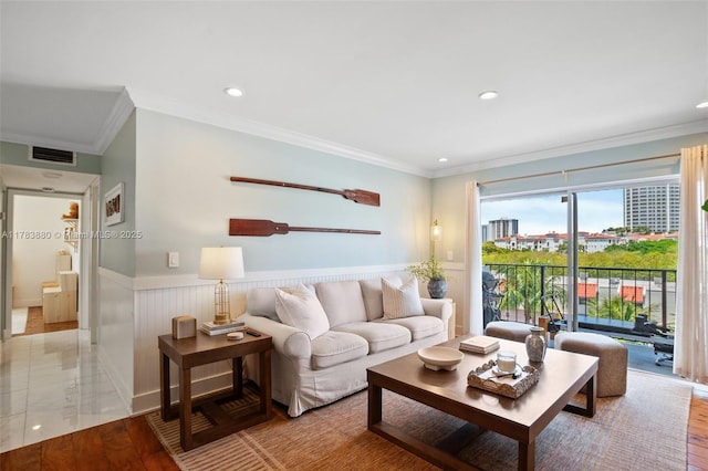 living room with recessed lighting, visible vents, crown molding, and a wainscoted wall