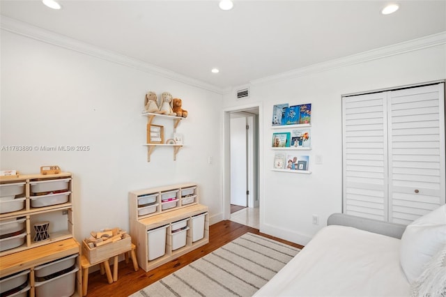 bedroom with crown molding, visible vents, recessed lighting, and wood finished floors