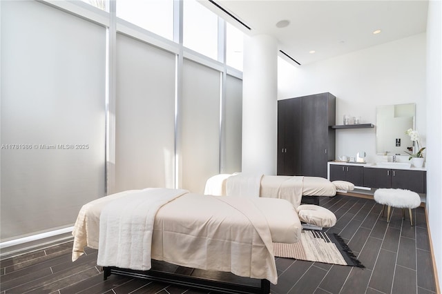 bedroom with recessed lighting, a sink, wood finish floors, and a towering ceiling