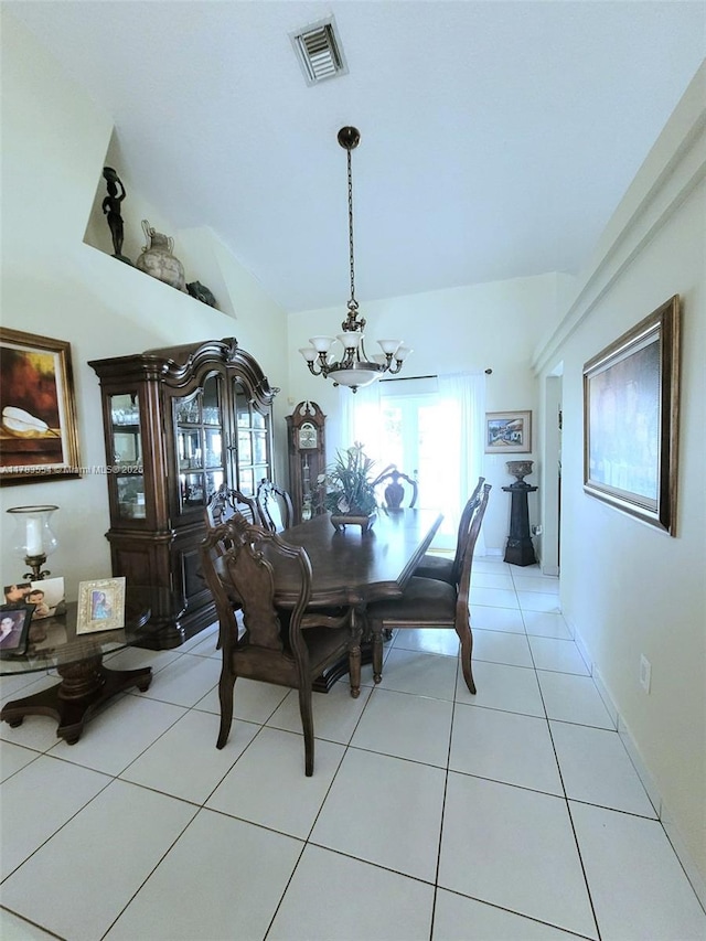 dining space with visible vents, vaulted ceiling, an inviting chandelier, and light tile patterned floors