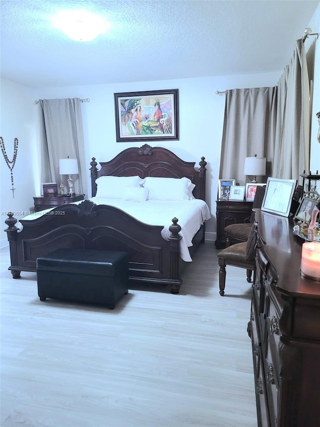 bedroom featuring wood finished floors and a textured ceiling