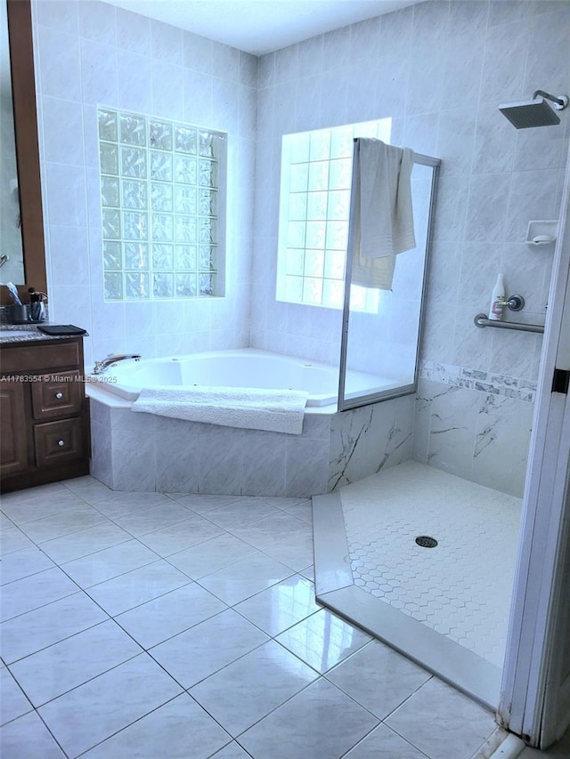 full bath with a tile shower, tile patterned floors, vanity, and a garden tub
