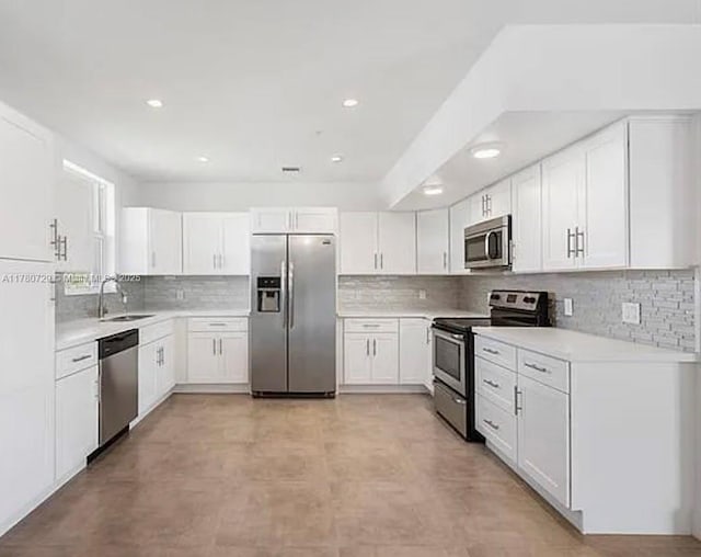 kitchen featuring a sink, backsplash, light countertops, and appliances with stainless steel finishes