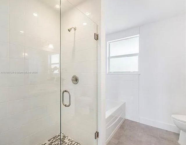 full bath featuring a bath, tile patterned flooring, toilet, and a stall shower