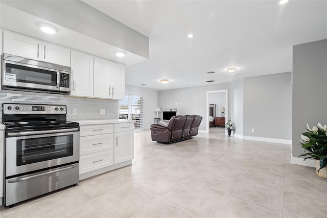 555 E Dania Beach Blvd Unit 4, Dania Beach, FL 33004 - kitchen with appliances with stainless steel finishes, light countertops, open floor plan, white cabinets, and recessed lighting