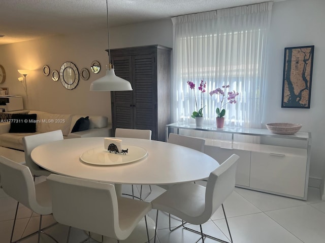 dining area featuring a textured ceiling and light tile patterned flooring