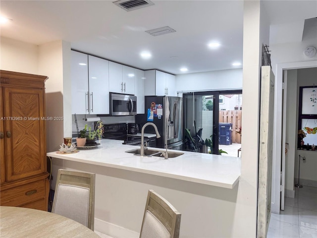 10505 SW 153rd Ct Unit 2, Miami, FL 33196 - kitchen featuring a peninsula, white cabinetry, visible vents, appliances with stainless steel finishes, and a sink