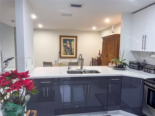 10505 SW 153rd Ct Unit 2, Miami, FL 33196 - kitchen with light countertops, a peninsula, a sink, and visible vents
