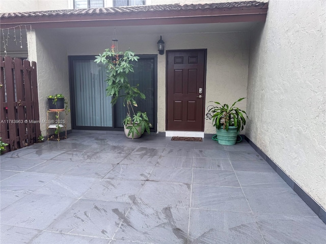 10505 SW 153rd Ct Unit 2, Miami, FL 33196 - view of exterior entry with stucco siding, fence, and a tile roof