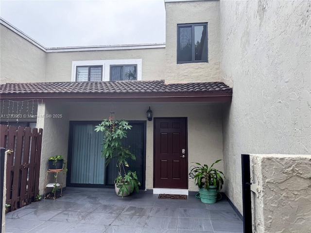 10505 SW 153rd Ct Unit 2, Miami, FL 33196 - view of exterior entry with stucco siding, a tiled roof, and fence