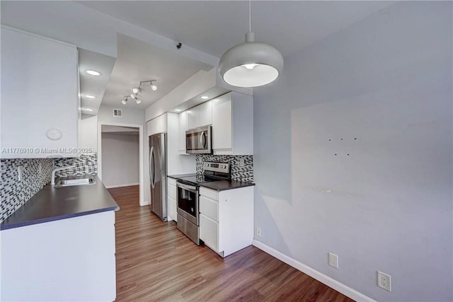19667 Turnberry Way Unit 3F, Aventura, FL 33180 - kitchen with appliances with stainless steel finishes, dark countertops, white cabinetry, decorative backsplash, and a sink