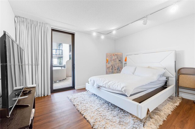 19667 Turnberry Way Unit 3F, Aventura, FL 33180 - bedroom with track lighting, access to outside, wood finished floors, and a textured ceiling