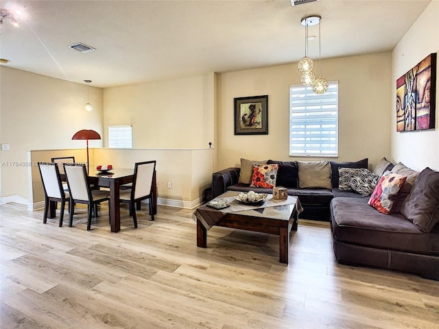 living area with visible vents, baseboards, and wood finished floors