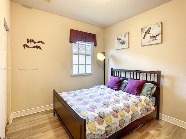 bedroom featuring baseboards and wood finished floors