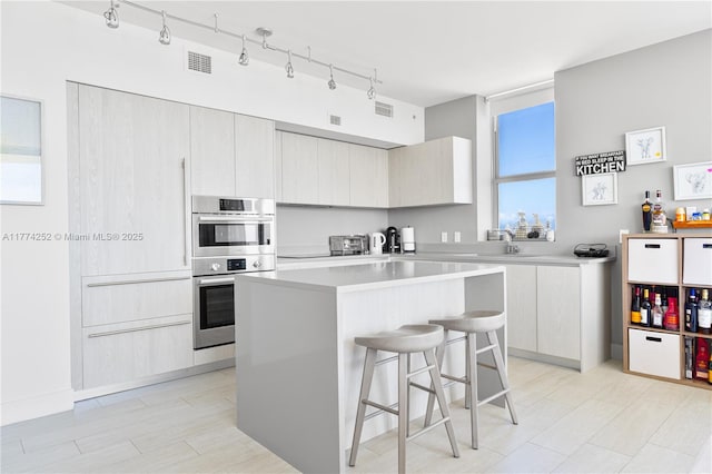 4010 S Ocean Dr Unit T3609, Hollywood, FL 33019 - kitchen with stainless steel double oven, light countertops, visible vents, a kitchen island, and a kitchen bar