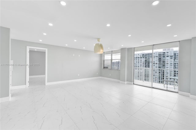 empty room featuring baseboards, recessed lighting, and marble finish floor