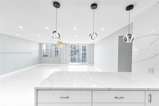kitchen featuring white cabinets, recessed lighting, light stone countertops, and open floor plan