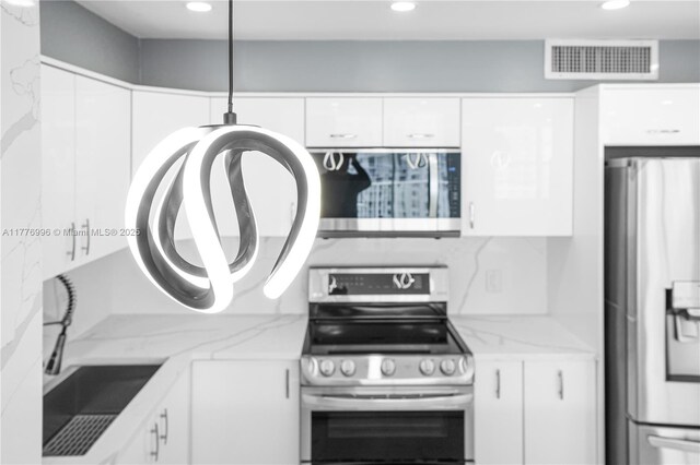 kitchen with visible vents, white cabinets, a sink, appliances with stainless steel finishes, and recessed lighting