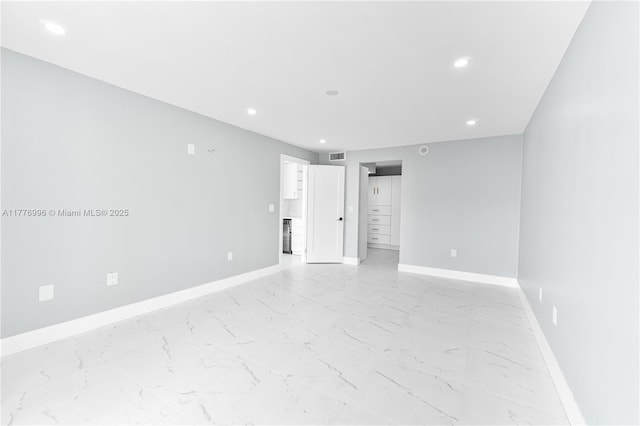 empty room featuring visible vents, baseboards, recessed lighting, and marble finish floor