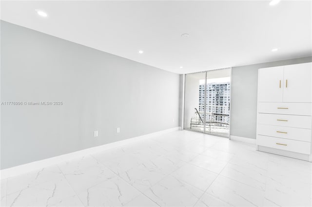 empty room featuring baseboards, recessed lighting, and marble finish floor