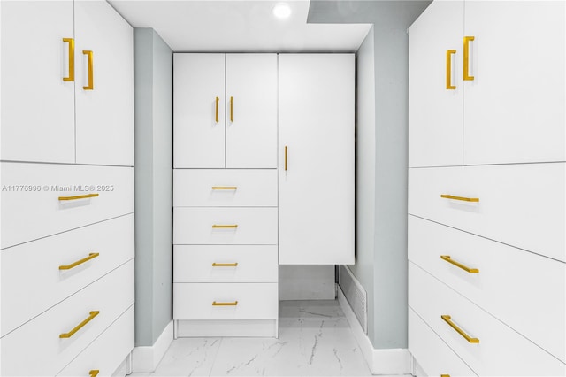 walk in closet with marble finish floor