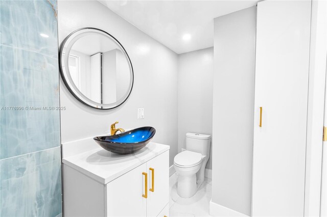 bathroom with vanity, marble finish floor, and toilet