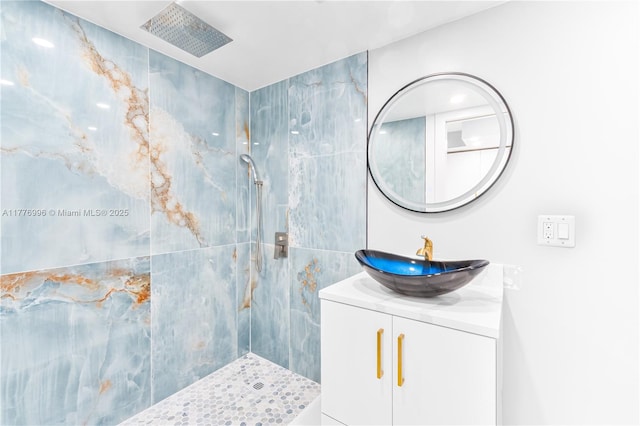 bathroom with vanity and a tile shower