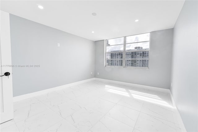 empty room with baseboards, recessed lighting, and marble finish floor