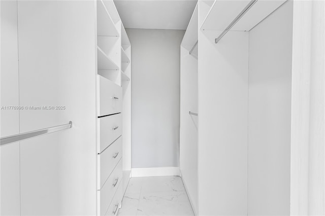 spacious closet featuring marble finish floor