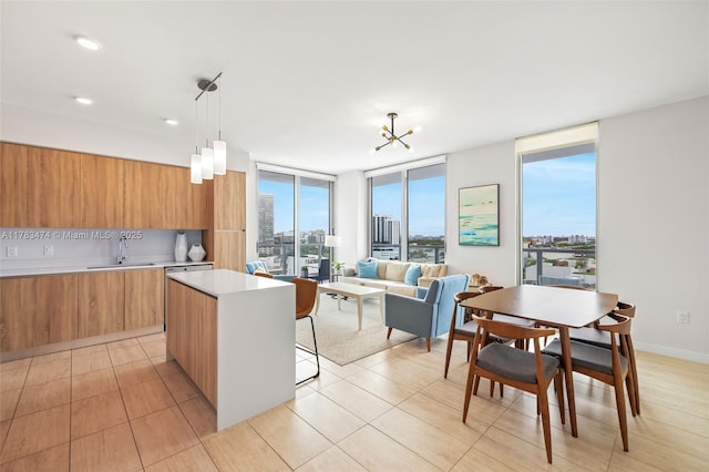 kitchen featuring light countertops, a sink, modern cabinets, a center island, and brown cabinetry