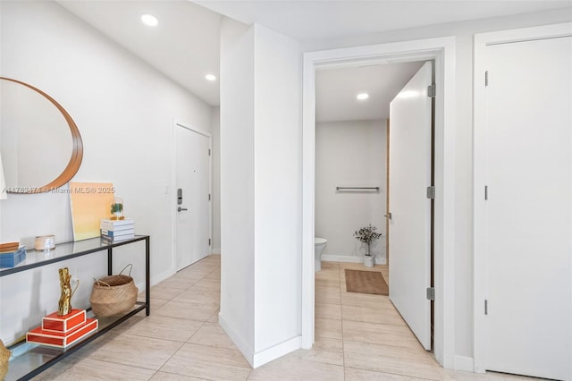 hall featuring recessed lighting, baseboards, and light tile patterned floors