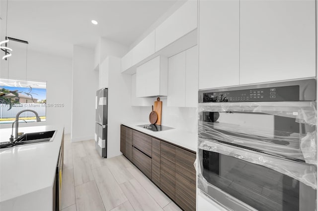 2138 SW 3rd Ave, Cape Coral, FL 33991 - kitchen with modern cabinets, white cabinetry, light countertops, freestanding refrigerator, and recessed lighting