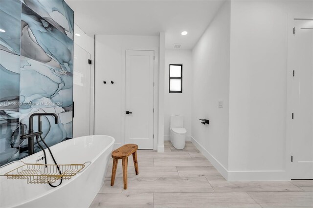 2138 SW 3rd Ave, Cape Coral, FL 33991 - bathroom featuring a freestanding bath, recessed lighting, and wood finished floors