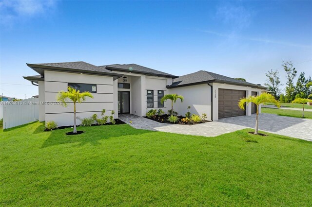 2138 SW 3rd Ave, Cape Coral, FL 33991 - prairie-style house featuring decorative driveway, stucco siding, and an attached garage